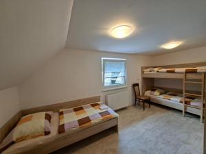 a bedroom with two bunk beds and a chair at Zavetišče v Gozdu in Križe