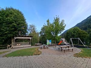 a park with benches and a playground with a slide at Zavetišče v Gozdu in Križe +6 photos