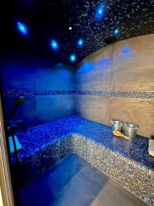 a room with a tub with blue lights in it at Suite Hortensia in Breuil-Barret