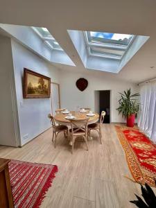 a dining room with a table and chairs and a ceiling at Suite Hortensia in Breuil-Barret