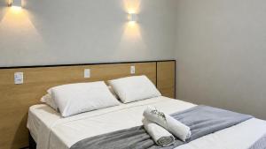 a bedroom with a bed with two pillows on it at Brisa do Lago Pousada in Capitólio