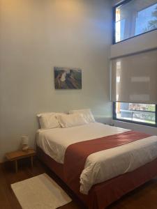 a bedroom with a large bed with a window at Aires de Quetzales in Concepción