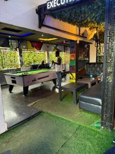a man standing in front of a pool table at Ofee Hotel and Suites in Nsukka