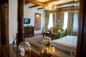 a bedroom with a bed and a couch and a mirror at Casa Ceauș in Baia-Sprie