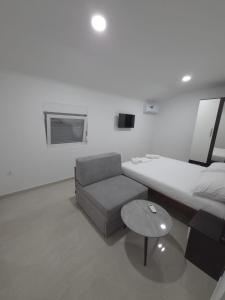 a room with a bed and a couch and a table at Villa Jopi in Neum