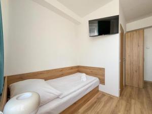 a bedroom with a bed with a tv on the wall at RS Hotel in Rimavská Sobota