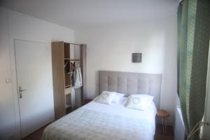 a bedroom with a white bed and a closet at hôtel du centre in Saint-Benoît-du-Sault