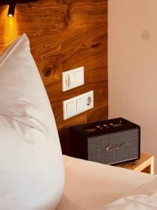 a bedroom with a bed with a speaker on the wall at Alpenzeit - Ferienhaus mit Sauna, Garten und Bergblick bei Garmisch-Partenkirchen in Farchant