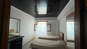 a small bedroom with two beds and a mirror at Mari House in Buknari