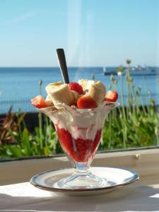 a dessert with fruit and whipped cream on a table at Mount Royal - Penzance in Penzance