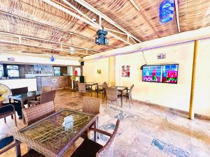 a dining room with tables and chairs and a tv at Presken Hotel Fajodd-4, Allen, Ikeja, Lagos in Ikeja