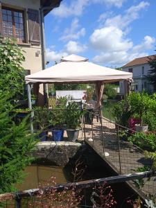 a patio with an umbrella and a pond at Le Moulin d'eclaron in Éclaron