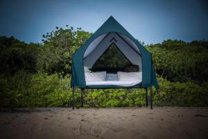 a bed in a tent on the beach at Kuma Surf Camp in Arugam Bay