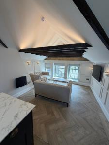a living room with a couch in the middle of a room at Oat & Olive Apartments - Alnwick in Alnwick