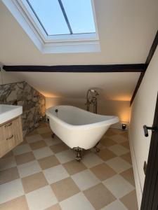 a bath tub in a bathroom with a skylight at Oat & Olive Apartments - Alnwick in Alnwick