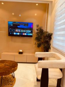 a living room with a tv on the wall at Eminoky Apartment in Lagos