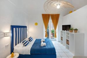 a bedroom with a blue bed and a tv at Casa Vacanza Sunshine in Meta