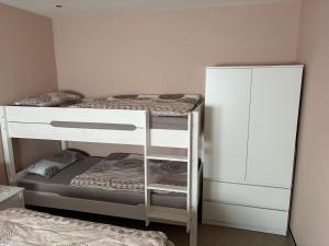 a small room with two bunk beds and a cabinet at Ferienwohnung Am Schlagbaum in Kaltennordheim