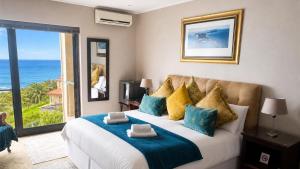 a bedroom with a large bed with a view of the ocean at Aqua Terra Boutique Guesthouse - Simon's Town, Cape Town in Simonʼs Town +55 photos