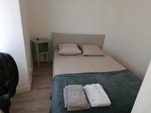 a small bedroom with a bed with two towels on it at Appart 1er étage Angers Chalouère in Angers
