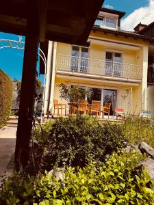 a house with chairs and a balcony on it at Alpenzeit - Ferienhaus mit Sauna, Garten und Bergblick bei Garmisch-Partenkirchen in Farchant