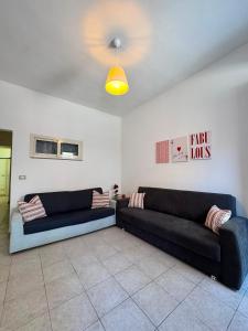 a living room with two black couches and a ceiling at Hour Home in Iglesias