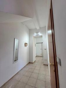 an empty hallway with a door and a tile floor at Hour Home in Iglesias