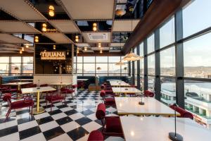 a restaurant with tables and chairs and a checkered floor at Hotel Indigo Tijuana Downtown by IHG in Tijuana +107 photos