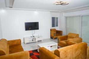 a living room with leather furniture and a flat screen tv at residence madame sow in Dakar