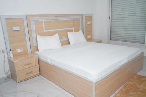 a bedroom with a large bed with a wooden headboard at residence madame sow in Dakar