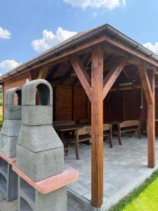 a wooden gazebo with a table and chairs at Agroturystyka Ostoja Wilków II in Wilków