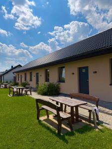a group of picnic tables in front of a building at Agroturystyka Ostoja Wilków II in Wilków