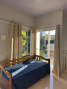 a bedroom with a bed and a large window at Chalés Aconchego in Cavalcante