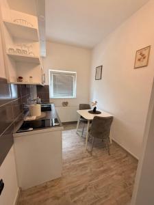 a kitchen and dining room with a table and chairs at Modern Cozy Apartment Lola in Doboj