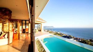a house with a swimming pool next to the ocean at Aqua Terra Boutique Guesthouse - Simon's Town, Cape Town in Simonʼs Town