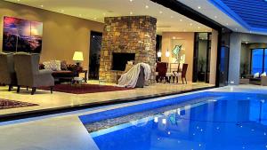 a swimming pool in a house with a fireplace at Aqua Terra Boutique Guesthouse - Simon's Town, Cape Town in Simonʼs Town