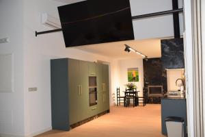 a living room with a green cabinet with a flat screen tv at Cortijo el Viznagar in Las Casicas