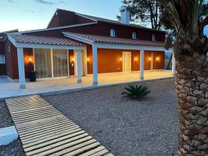 a house with a wooden walkway in front of it at Cortijo el Viznagar in Las Casicas