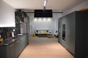 a kitchen with grey cabinets and a couch in the background at Cortijo el Viznagar in Las Casicas
