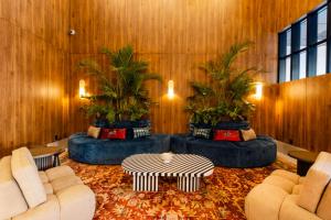 a living room with two couches and palm trees at Hotel Indigo Tijuana Downtown by IHG in Tijuana