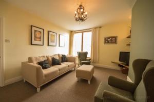 a living room with a couch and a tv at Belle Vue Terrace Apartment in Great Malvern