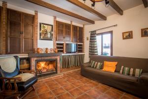 a living room with a couch and a fireplace at Casa Rural Espinarural in Almogía