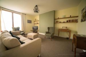 uma sala de estar com um sofá e cadeiras e uma secretária em Belle Vue Terrace Apartment em Great Malvern