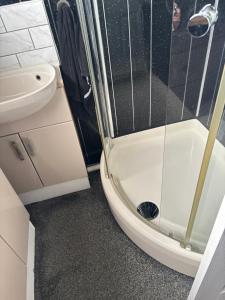 a bathroom with a shower and a toilet and a sink at Retreat to the Chalet in Withernsea +6 photos