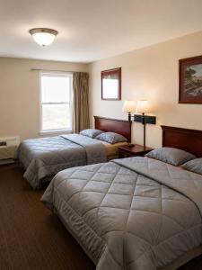a hotel room with two beds and a window at Tumbleweed Inn & Suites in Alexander