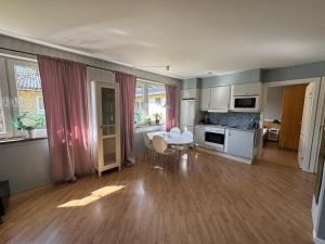a living room with a kitchen with a table and chairs at Ekängens vandrarhem in Virserum
