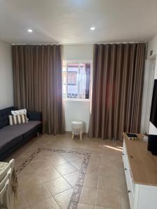 a living room with a couch and a tv at Casa da Maré in Calheta