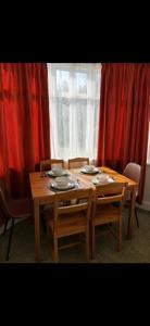 a wooden table with four chairs and a window at Riverside all for you in Kingston upon Thames