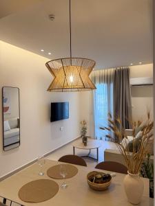 a living room with a table and a chandelier at Elia Stay in Kalives Poligirou