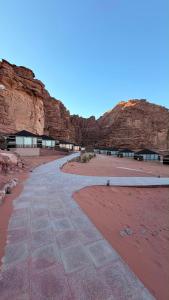 a walkway in front of a rocky mountain at Wadi Rum Bella Rose Luxury Camp in Disah